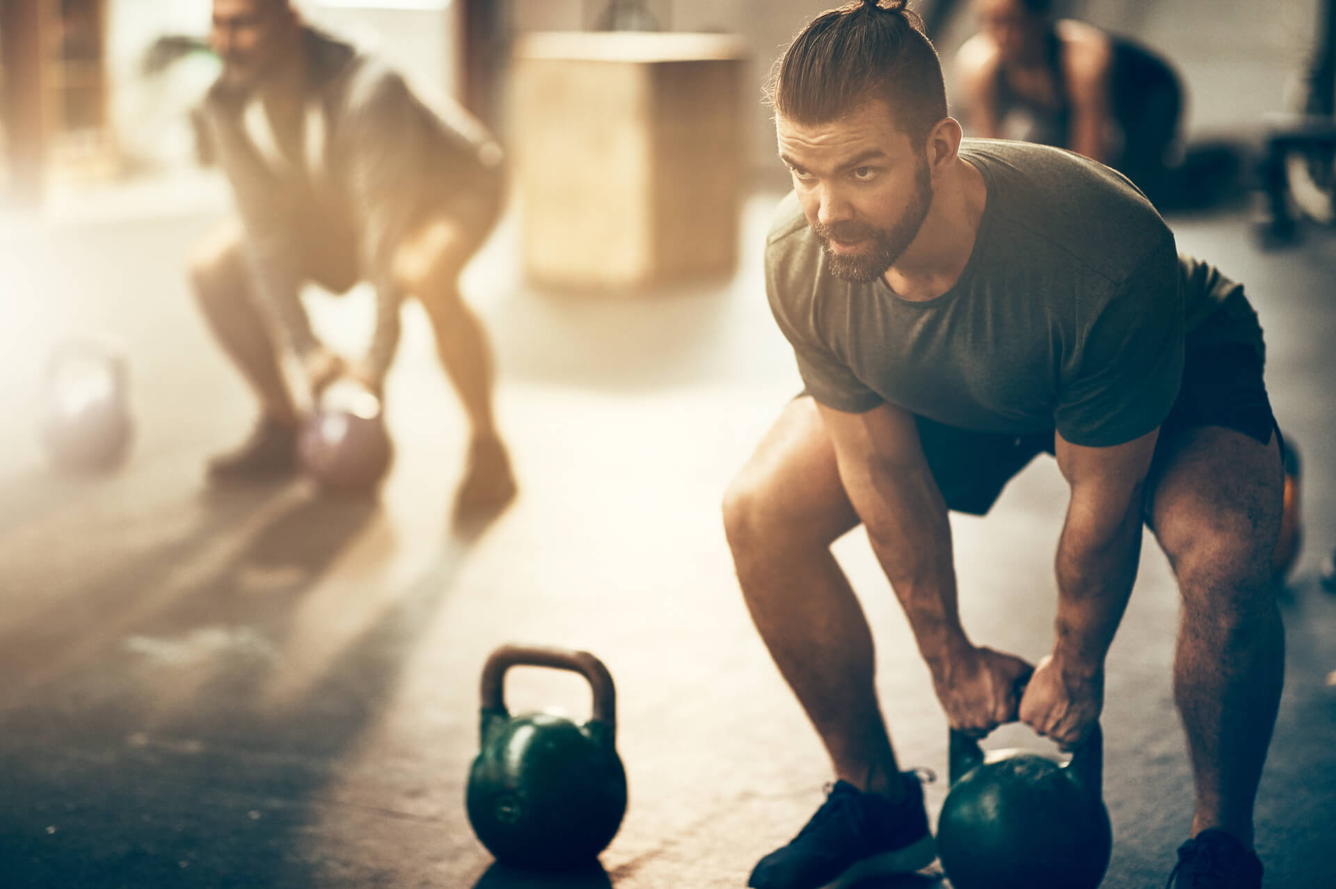 Persoane lucrand cu greutati in sala de fitness